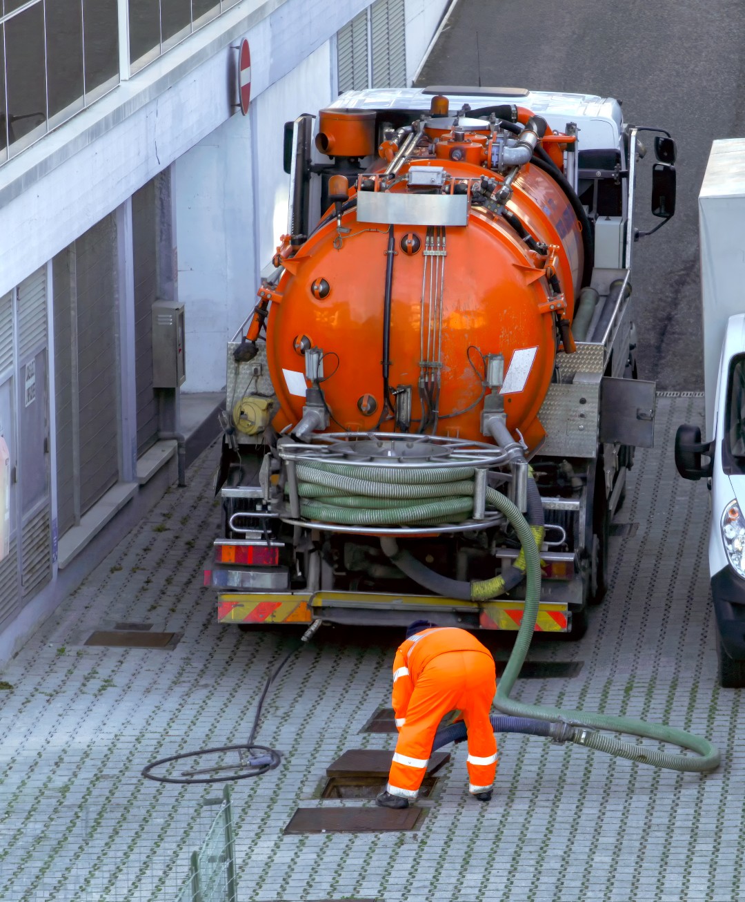 worker performing a vacuum truck service for industrial needs